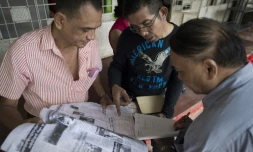 Les partisans d'Aung San Suu Kyi consultent les résultats des élections dans un quotidien le 10 novembre 2015 à Rangoun