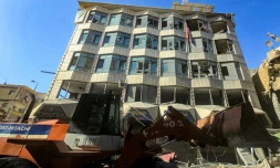 Un bulldozer déblaye des débris et gravats devant un bâtiment endommagé après des bombardements israéliens nocturnes sur la ville de Tyr, dans le sud du Liban, le 16 mai 2026