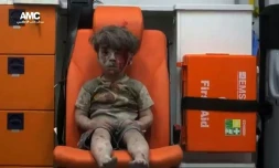 Le petit Omrane, 4 ans, assis à l'arrière d'une ambulance après avoir été sauvé d'un immeuble bombardé à Alep le 17 août 2016