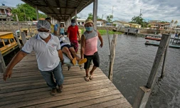 Un patient présentant des symptÎmes du coronavirus est porté sur un brancard avant son transfert pour un hÎpital par voie fluviale, à Melgaço (Brésil), le 10 juin 2020