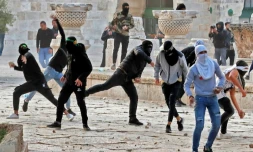 Des Palestiniens lancent des pierres sur la police israélienne, le 22 avril 2022 à Jérusalem