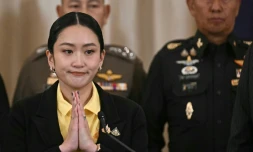 La Première ministre thaïlandaise Paetongtarn Shinawatra (g) joint ses mains lors d'une conférence de presse aux côtés du commandant des forces armées Pana Klaewplodthuk (d) au siège du gouvernement à Bangkok, le 19 juin 2025