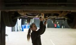 Une femme mécanicienne répare une voiture le 14 mai 2014 à Saint-Ouen-l'Aumone.