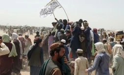 Des Afghans agitent des drapeaux talibans pour célébrer la prise de contrôle par les combattants islamistes d'un poste-frontière avec le Pakistan, à Spin Boldak, le 14 juillet 2021.