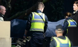 Le 6 juin 2017 à Brighton, dans la banlieue de Melbourne, des policiers aident le médecin légiste à évacuer le corps du preneur d'otage abattu à l'issue d'échanges de tirs avec la police