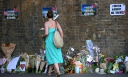 Une femme dépose des fleurs près des lieux d'une attaque contre des piétons devant une mosquée à Londres, le 19 juin 2017