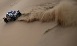La Mini pilotée par Stéphane Peterhansel fend les dunes du Dakar en direction de Yanbu, en Arabie saoudite, le 14 janvier 2021
