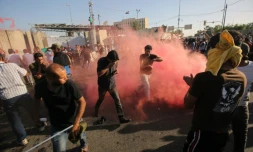 Des manifestants fuient les gaz lacrymogÚnes lancés par les forces de l'ordre à Bagdad le 20 mai 2016