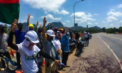 Photo diffusée par Eindu Youths le 6 avril 2021 montrant des manifestants faisant le salut à trois doigts et déversant de la peinture rouge sur une route à Hpa-an, capitale de l'Etat Karen, dans le sud de la Birmanie