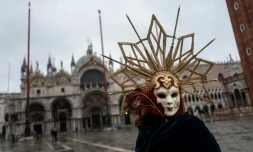 Un artisan vénitien portant un masque et un costume de carnaval sur la place Saint-Marc à Venise (Italie), le 7 février 2021