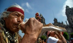 Un autochtone souffle dans une corne "atecocolli", un instrument qui remonte à l'époque des Aztèques, sur la place du Zocalo, dans le centre de Mexico le 12 août 2021.