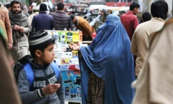 Une femme en burqa fait la manche sur un marché de Jalalabad, en Afghanistan, le 1er février 2023