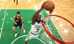 Jaylen Brown (c.), des Boston Celtics, tente un dunk contre Klay Thompson (g.), des Golden State Warriors, lors du troisième match des finales NBA, à Boston, le 8 juin 2022
