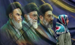 Une Iranienne passe devant les portraits des trois guides suprêmes iraniens depuis l'avènement de la République islamique, le 28 mai 2026 à Téhéran