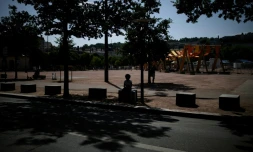 Une personne est assise à l'ombre d'arbres à Lyon, le 25 juin 2025