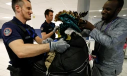 Un douanier aide un passager à refaire son sac après une fouille à l'aéroport Roissy-Charles-de-Gaulle, le 26 juillet 2016