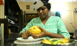Nagireddy Sriramyachandra filme avec un téléphone ses gestes pendant qu'elle coupe une mangue pour entraîner un futur robot dopé à l'IA, le 15 mai 2026 à Madras, en Inde
