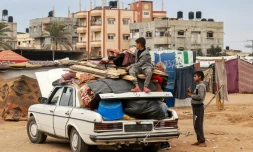 Des Palestiniens chargent une voiture de leur affaires pour quitter Rafah face à la menace d'une offensive militaire israélienne sur la ville, le 13 février 2024 dans le sud de la bande de Gaza