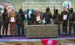 Des combattants palestiniens du Hamas encadrent trois otages israéliens sur un podium avant de les remettre à la Croix-Rouge à Deir el-Balah, dans le centre de Gaza, le 8 février 2025