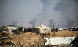 Des tentes de Palestiniens déplacés dans le camp de réfugiés de Nousseirat, dans le centre de la bande de Gaza, tandis que des panaches de fumée s'élèvent au-dessus de la ville de Gaza, bombardée par Israël, le 19 septembre 2025.