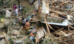 Des habitants récupÚrent des biens dans leurs maisons détruites à Talisay, dans la province de Cebu, le 17 décembre 2021, un jour aprÚs le passage du super typhon Rai