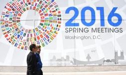Deux hommes passent devant un panneau annonçant le meeting du monde de la finance à Washington, le 13 avril 2016