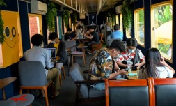 Des personnes attablées dans un wagon de train reconverti en café, le 5 juin 2021 à Phnom Penh, au Cambodge