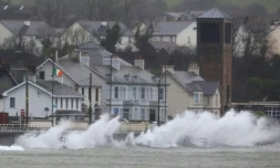 Des vagues se brisent contre la digue à Carnlough, sur la côte nord-est de l'Irlande du Nord, pendant la tempête Eowyn, le 24 janvier 2025