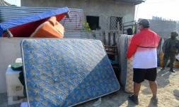 Un homme sort les meubles et les biens des personnes qui avaient extorqué et expulsé sa famille après avoir récupéré sa maison lors d'une opération de l'armée et de la police à Duran, le 23 juillet 2024 en Equateur