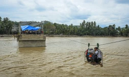 Des villageois utilisent une cabine sur câble pour traverser une rivière après la destruction d'un pont à Bireuen, en Indonésie, le 2 décembre 2025
