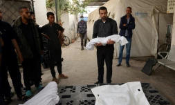 Un homme porte le corps d'un enfant tué lors d'un bombardement israélien, devant la morgue d'un hÎpital de Rafah, dans le sud de la bande de Gaza, le 27 avril 2024