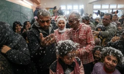 Afnan (centre), son pĂšre (Ă sa gauche) et son mari Mustafa (Ă droite) sont couverts de mousse lors de leur mariage dans le sud de la bande de Gaza, le 12 janvier 2024