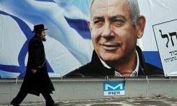 Un orthodoxe juif marche devant une affiche électorale du Premier ministre israélien Benjamin Netanyahu, le 1er avril 2019 à Jérusalem