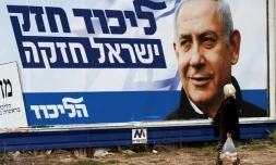 Une arabe israélienne marche devant une affiche électorale montrant le Premier ministre israélien Benjamin Netanyahu, à Haïfa (nord), le 4 avril 2019