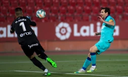 L'attaquant argentin de Barcelone, Lionel Messi (d), défie le gardien espagnol de Majorque, Manolo Reina, lors du match de Liga à Palma de Majorque, le 13 juin 2020