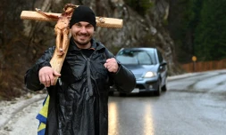 Josip Jelinic, une croix de 8 kilos sur l'épaule, marche le long d'une route pendant son pèlerinage de 1000 km demandant le pardon et la réconciliation de tous les peuples en Bosnie-Herzégovine, près de la ville de Vares, le 25 mars 2025