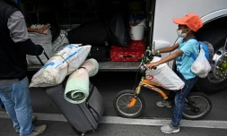 Des migrants vénézuéliens s'apprêtent à prendre un autocar pour retourner dans leur pays, le 14 avril 2020 à Cali, en Colombie