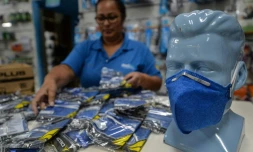 Une employée de pharmacie devant un stock de masques de protection à Sao Paulo (Brésil) le 27 février 2020