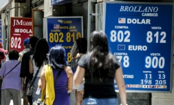 Des passants devant des bureaux de change à Santiago du Chili, le 2 décembre 2019