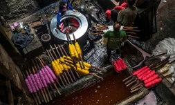 Des employés de l'une des dernières teintureries artisanales de la capitale égyptienne teignent des fils de coton le 21 janvier 2020, dans le quartier de Darb al-Ahmar (vieux Caire islamique)