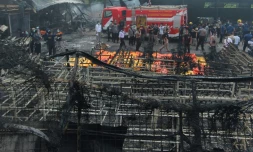 Policiers et équipes de secours sur les lieux d'un incendie qui a ravagé une usine de feux d'artifice, le 26 octobre 2017 à Tangerang Kota, en Indonésie