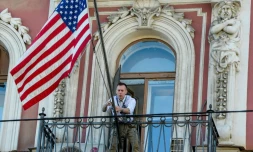Un employé du consulat américain de Saint Pétersbourg fixe la banniÚre étoilée sur le balcon du consulat, le 31 mars 2018