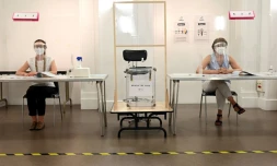 Des bénévoles dans un bureau de vote avant le second tour des municipales, à Paris le 26 juin 2020