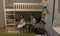 Nadiya Mikhailyuk lit un livre à cÎté de son frÚre Makar avant la rentrée des classes, le 1er septembre 2023 à Irpin, prÚs de Kiev, en Ukraine