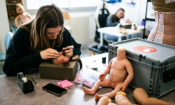 Une technicienne d'atelier implante de la laine pour simuler une chevelure sur de faux bébés en silicone dans les locaux de l'entreprise Cinébébé, le 27 janvier 2025 à Saint-Denis, près de Paris
