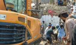 Des personnes transportent le corps d'une victime après un attentat contre un poste de contrôle de police à Bannu, dans le nord-ouest du Pakistan, le 10 mai 2026
