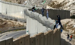 Des Palestiniens debout sur le mur séparant la ville d'Abu Dis en Cisjordanie et Jérusalem est le 28 octobre 2015