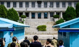 Des journalistes photographient la ligne de démarcation séparant la Corée du Nord et la Corée du Sud, à Panmunjom, avec le Panmon Hall au fond, situé en Corée du Nord, le 18 juillet 2023