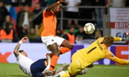 L'attaquant néerlandais Quincy Promes (c) entre le gardien de but anglais Jordan Pickford (d) et le défenseur Kyle Walker qui marque contre son camp en demi-finale de la Ligue des nations, le 6 juin 2019 à Guimaraes