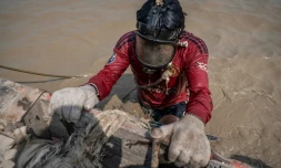 Un homme plonge dans les eaux boueuses du fleuve Yangon pour remonter des épaves, le 27 février 2024 à Rangoun, en Birmanie